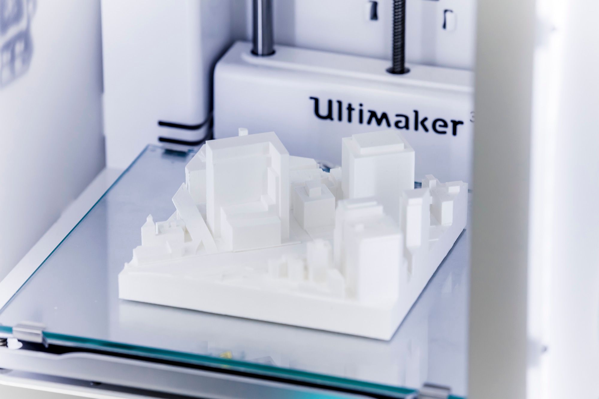 Maqueta urbana blanca impresa en 3D sobre la base de una impresora 3D