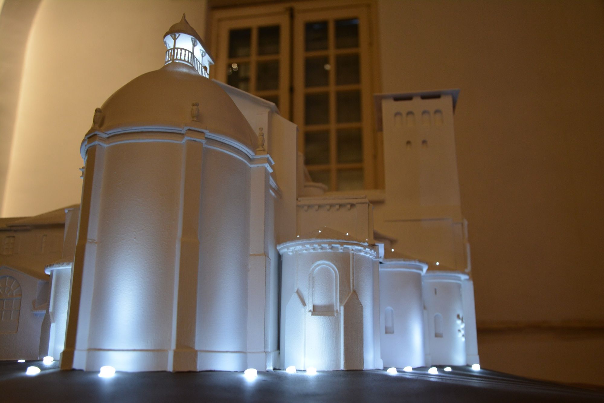 Maqueta blanca interactiva de una abadía románica iluminada con puntos LED integrados en la base