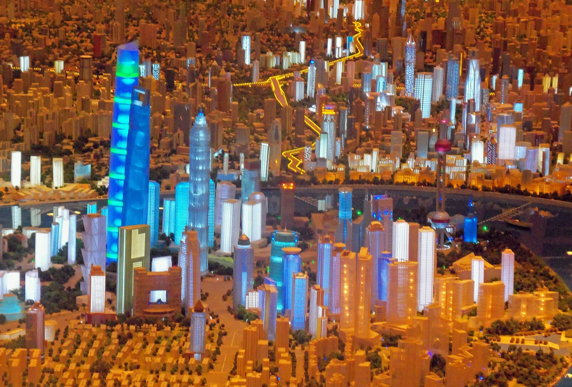 Maqueta urbana de Shanghái con rascacielos iluminados por LED en tonos azules y blancos junto al río